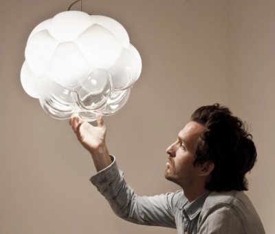 Mathieu Lehanneur, pictured here holding his Cloudy Lamp, uses glass to diffuse the sometimes cold light of LED technology.